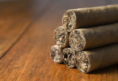 Cigars habanos huddled on wood background clipart