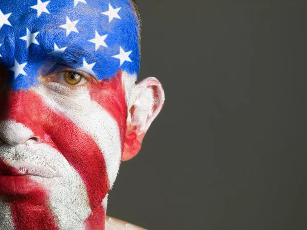 Man gezicht beschilderd met de vlag van Verenigde Staten, triest expressie — Stockfoto