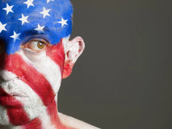 Man gezicht beschilderd met vlag van Verenigde Staten, kijkend naar kant — Stockfoto