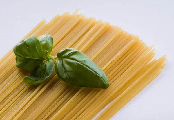 Massa de espaguete com folhas de manjericão frescas — Fotografia de Stock