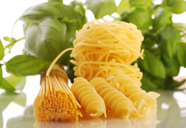Various types of pasta with basil and tomatoes — Stock Photo, Image