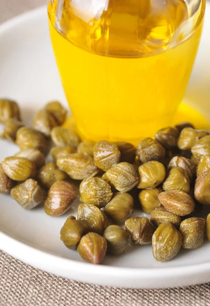 Capers and olive oil on the plate — Stock Photo, Image