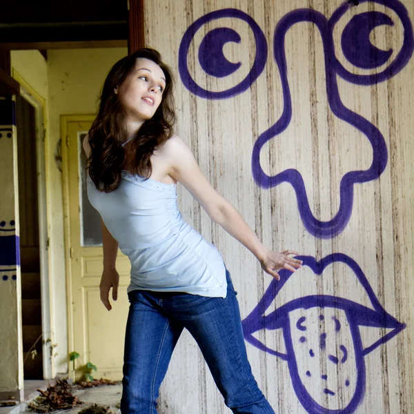 Vrouw dansen in de buurt van een graffiti. — Stockfoto