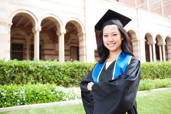 Schöne junge asiatische Frau in Abschlussmütze und Kleid — Stockfoto