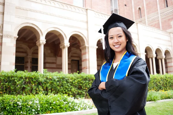 Beautiful young asian woman in graduation cap and gown — Stock Photo, Image