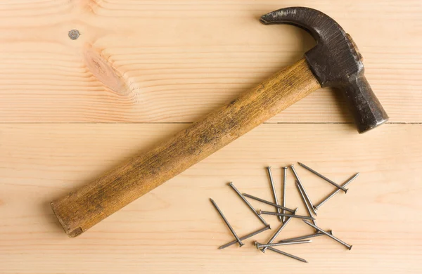 Unhas de martelo e ferro velhas no chão de madeira — Fotografia de Stock