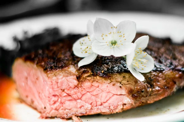 Bife de carne fresca com flor — Fotografia de Stock