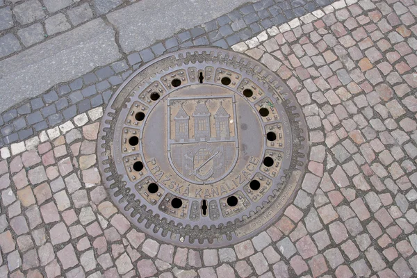 Sewer manhole with ñoat of arms of Prague — Stock Fotó