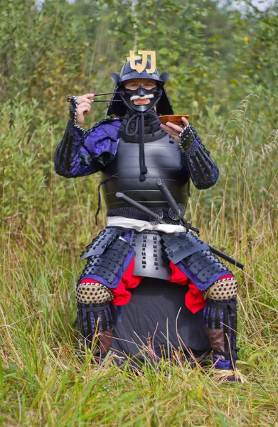 stock image Samurai in armor with chopsticks and plate