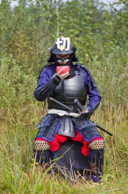 Samurai in armor drinking from bowl clipart