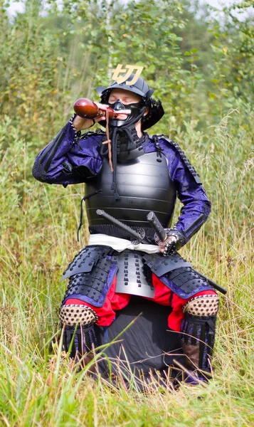 Samurai in harnas drinken uit kolf — Stockfoto