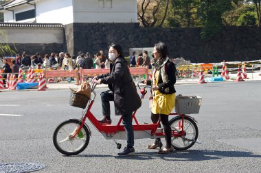 Women at tandem bicycle clipart