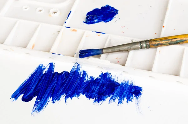 Pincel viejo y paleta con pintura azul — Foto de Stock