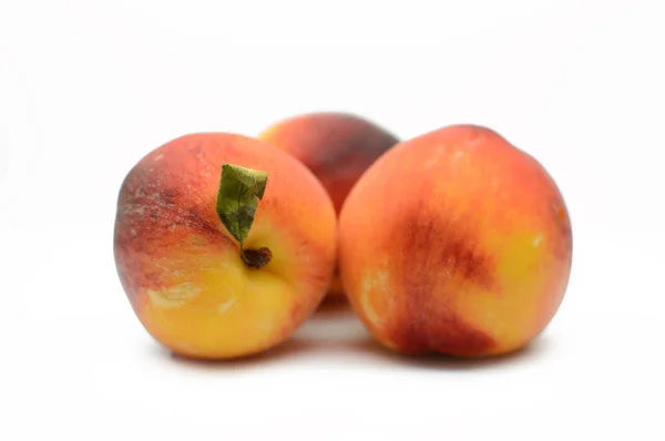Saftiga persikor på vit bakgrund — Stockfoto