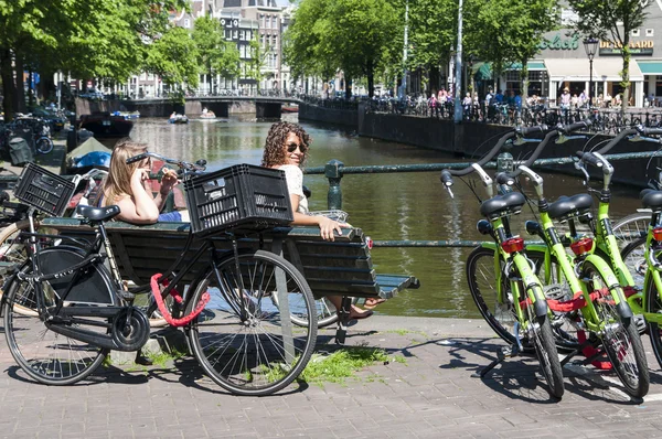 Amsterdam, Nizozemsko - 27. května: Nizozemci sedí blízko rušné — Stock fotografie