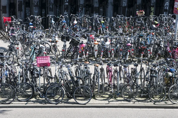 AMSTERDAM, HOLANDA - 28 DE MAYO: ocupado estacionamiento de bicicletas cerca de t —  Fotos de Stock