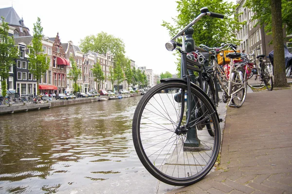 AMSTERDAM, HOLANDA - 29 DE MAYO: Detalle de bicicleta encadenada por canal —  Fotos de Stock