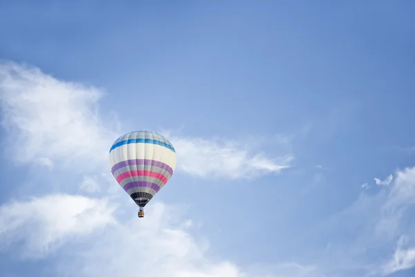 Globo de aire caliente aislado en un cielo azul Imágenes de stock libres de derechos