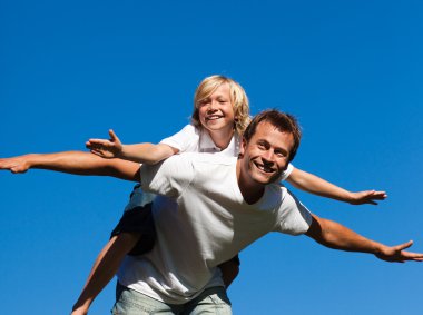 Happy father with his son on his back outdoor clipart
