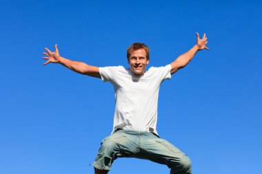 Portrait of a Young Man jumping in the air outdoor clipart