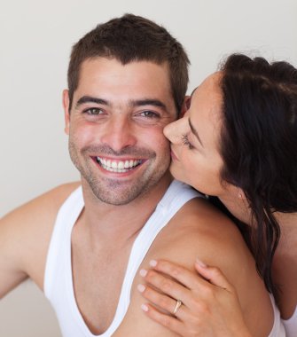 Portrait of girlfriend kissing her smiling boyfriend clipart