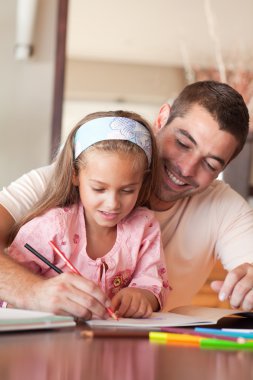 Concentrated girl painting with her father clipart