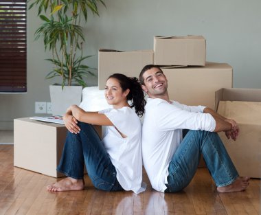 Glowing couple relaxing after buying a house clipart