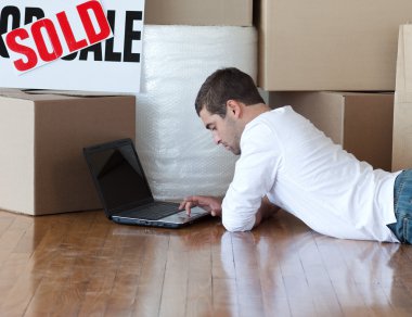 Young man lying on the floor in his new house clipart