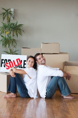 Cheerful couple sitting on the floor clipart