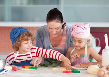 Beautiful mother helping their chilldren baking clipart