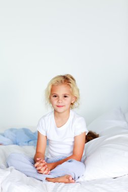 Adorable girl on a bed clipart