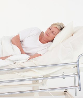 Elderly patient in white bed clipart