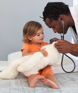 Doctor with a cute child in a hospital clipart