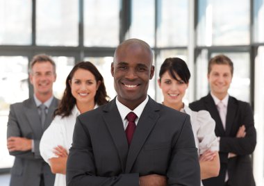 Smiling confident business team looking at the camera clipart