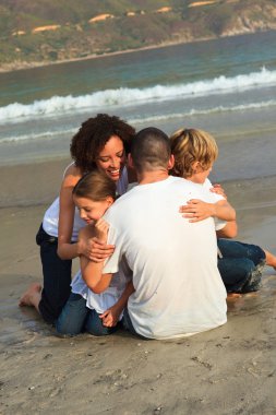 Young Family on the beach having fun clipart