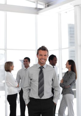 Young business manager standing at the camera with his team clipart