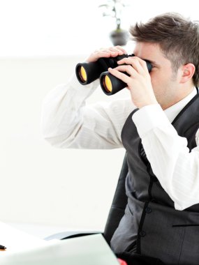 Close-up of a young businessman looking through binoculars isola clipart