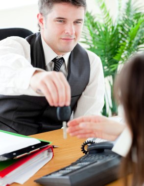 Charming salesman giving car's key to his customer clipart