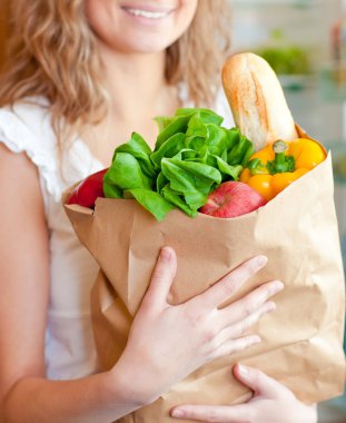 Smiling woman holding a shopping bag clipart