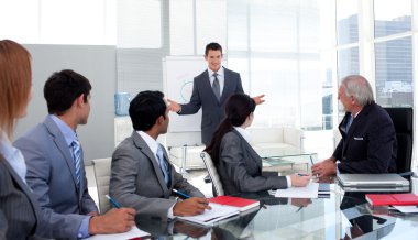 Confident businessman giving a presentation to his team clipart