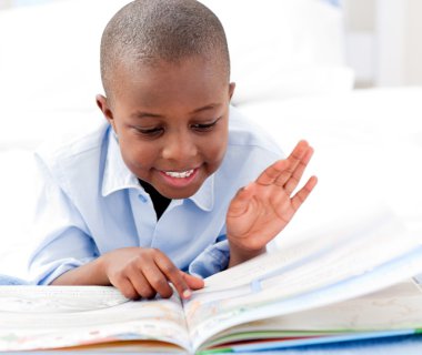 Small boy reading a book clipart