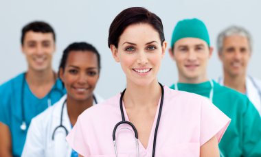 Female Doctor standing in Front of her team clipart