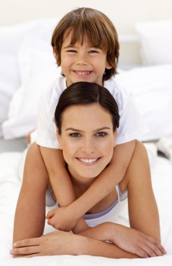 Son hugging his mother in bed clipart