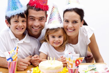 Family celebrating daughter's birthday at home clipart