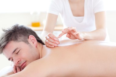 Smiling young man in an acupuncture therapy clipart