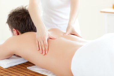 Caucsasian young man receiving a back massage clipart