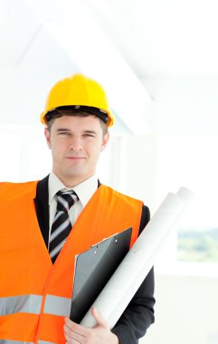 Young male architect holding blueprints clipart