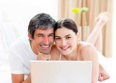 Happy couple using a laptop clipart