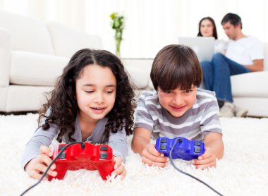 Cute siblings playing video games laying down on the floor clipart