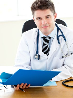 Self-assured doctor reading a report clipart